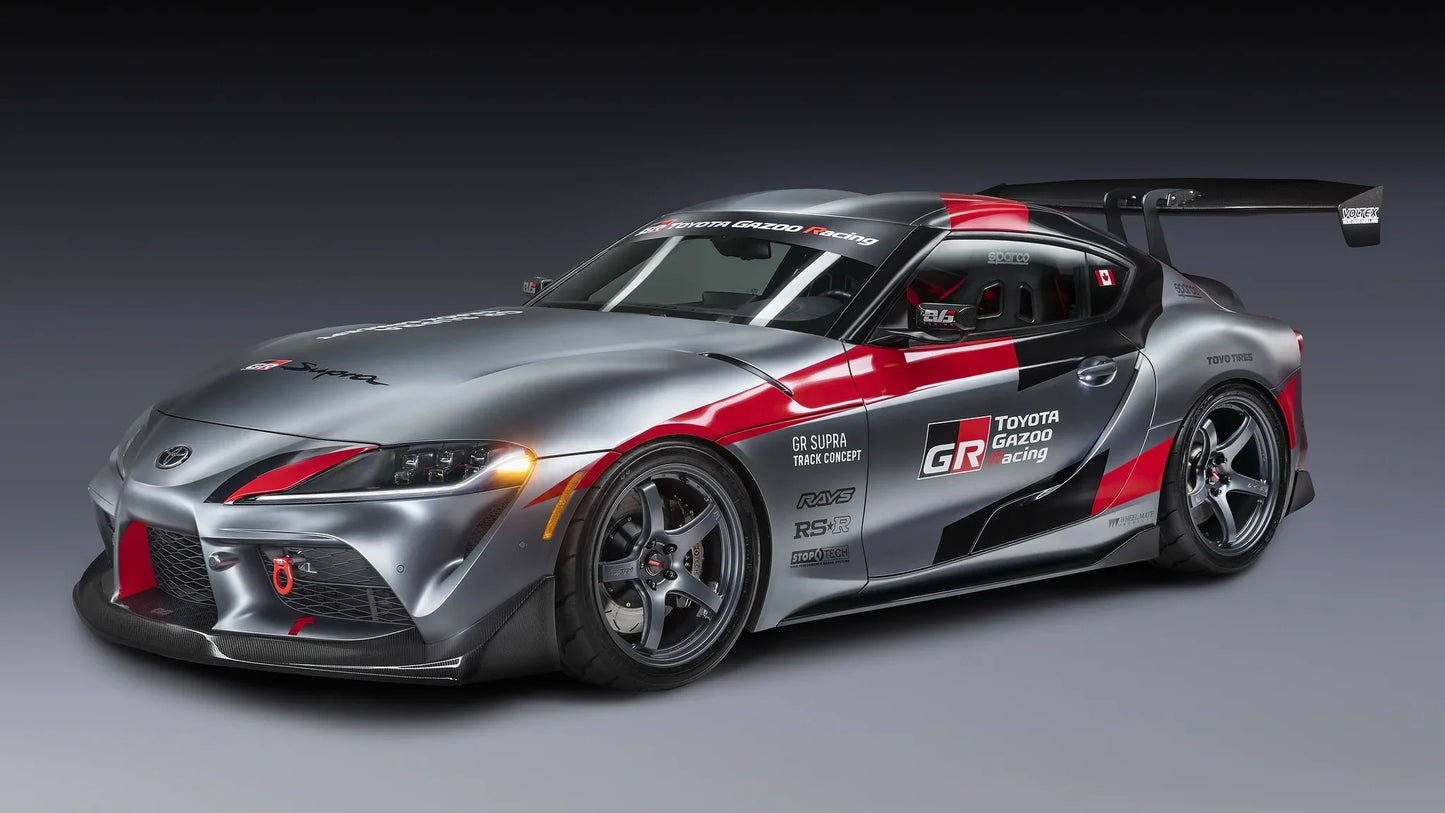 Silver and red Toyota GR Supra Track Concept race car with large rear wing on gray background