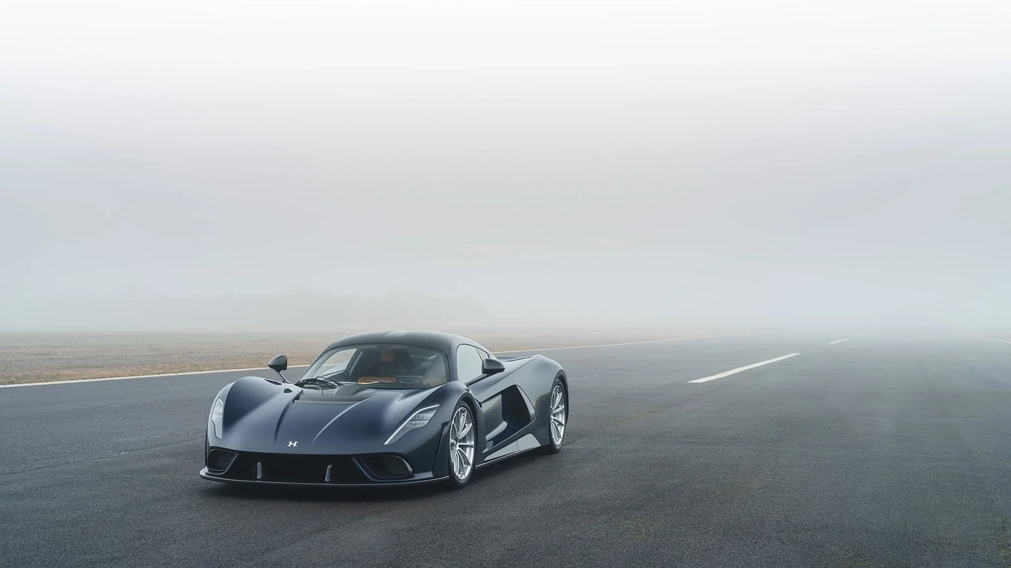 Hennessey Venom F5 black sports car on foggy runway with sleek aerodynamic design