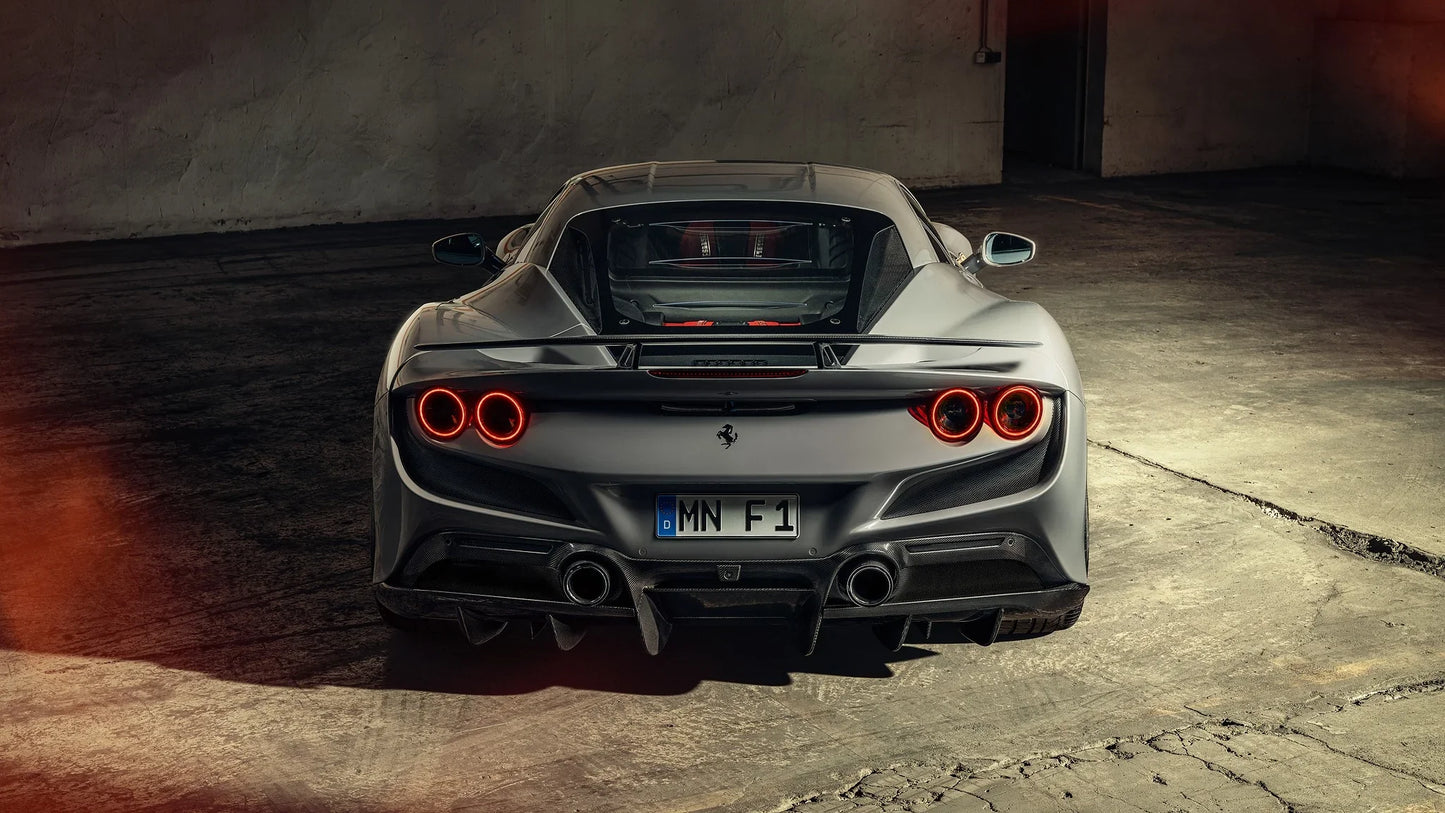 Rear view of silver Novitec Ferrari F8 Tributo with illuminated circular taillights in dim garage