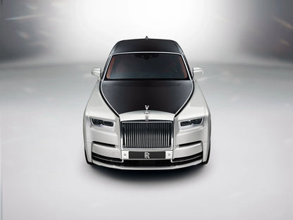 Front view of 2017 Rolls-Royce Phantom luxury car with black hood and silver body on gray background