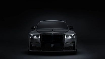 Front view of a black Rolls-Royce Ghost Black Badge luxury car with illuminated headlights