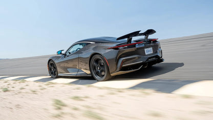 Black Pininfarina Battista electric hypercar on race track with rear spoiler