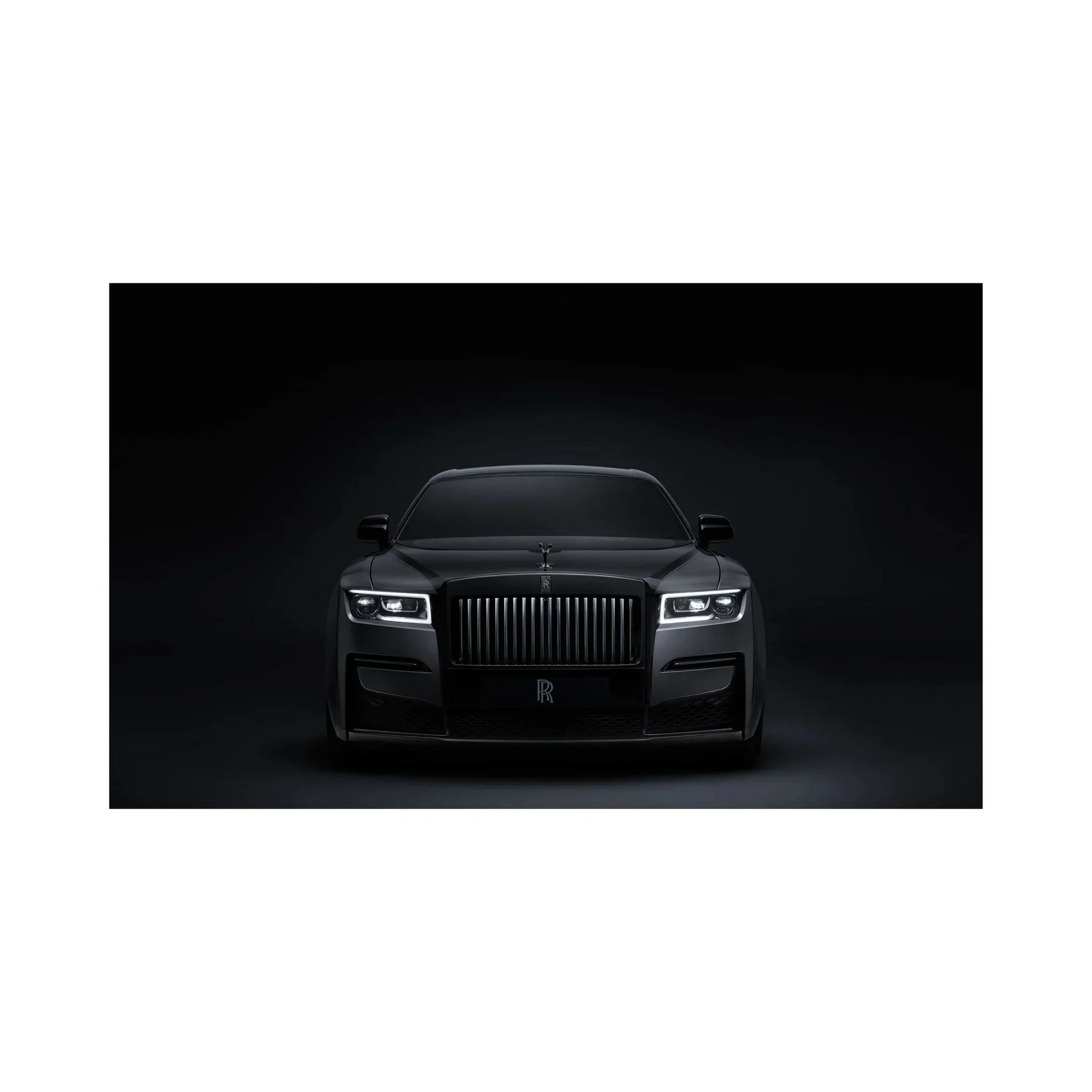 Front view of a sleek black Rolls-Royce luxury car with illuminated headlights against a dark background