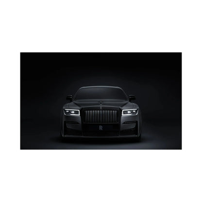Front view of a sleek black Rolls-Royce luxury car with illuminated headlights against a dark background