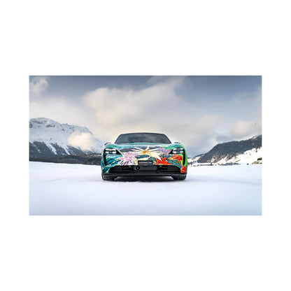 Front view of a Porsche sports car with colorful floral art wrap on snowy mountain landscape