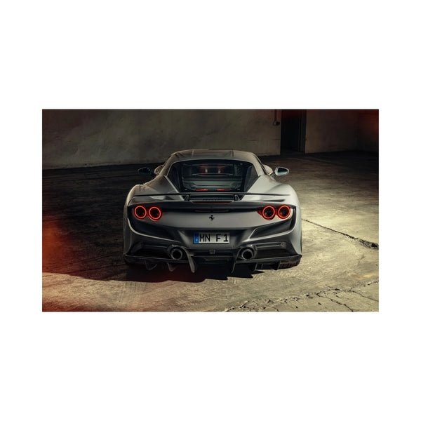 Rear view of silver Ferrari F8 Tributo sports car with quad circular taillights in dim garage
