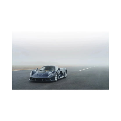 Black sports car parked on foggy tarmac road with overcast sky in background