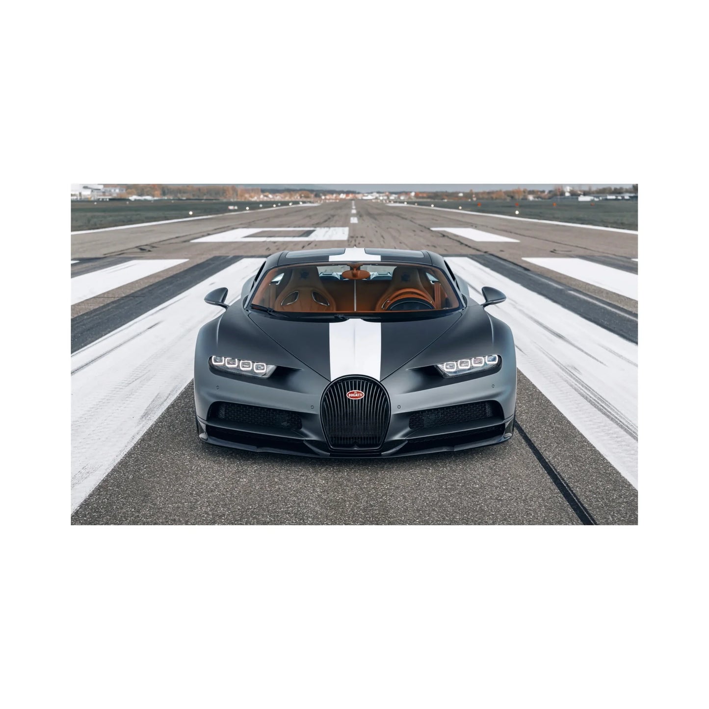 Front view of black Bugatti Chiron with white racing stripe parked on runway