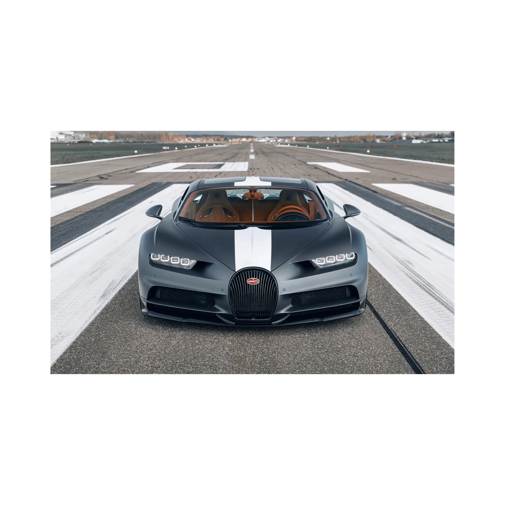 Front view of black Bugatti Chiron with white racing stripe parked on runway