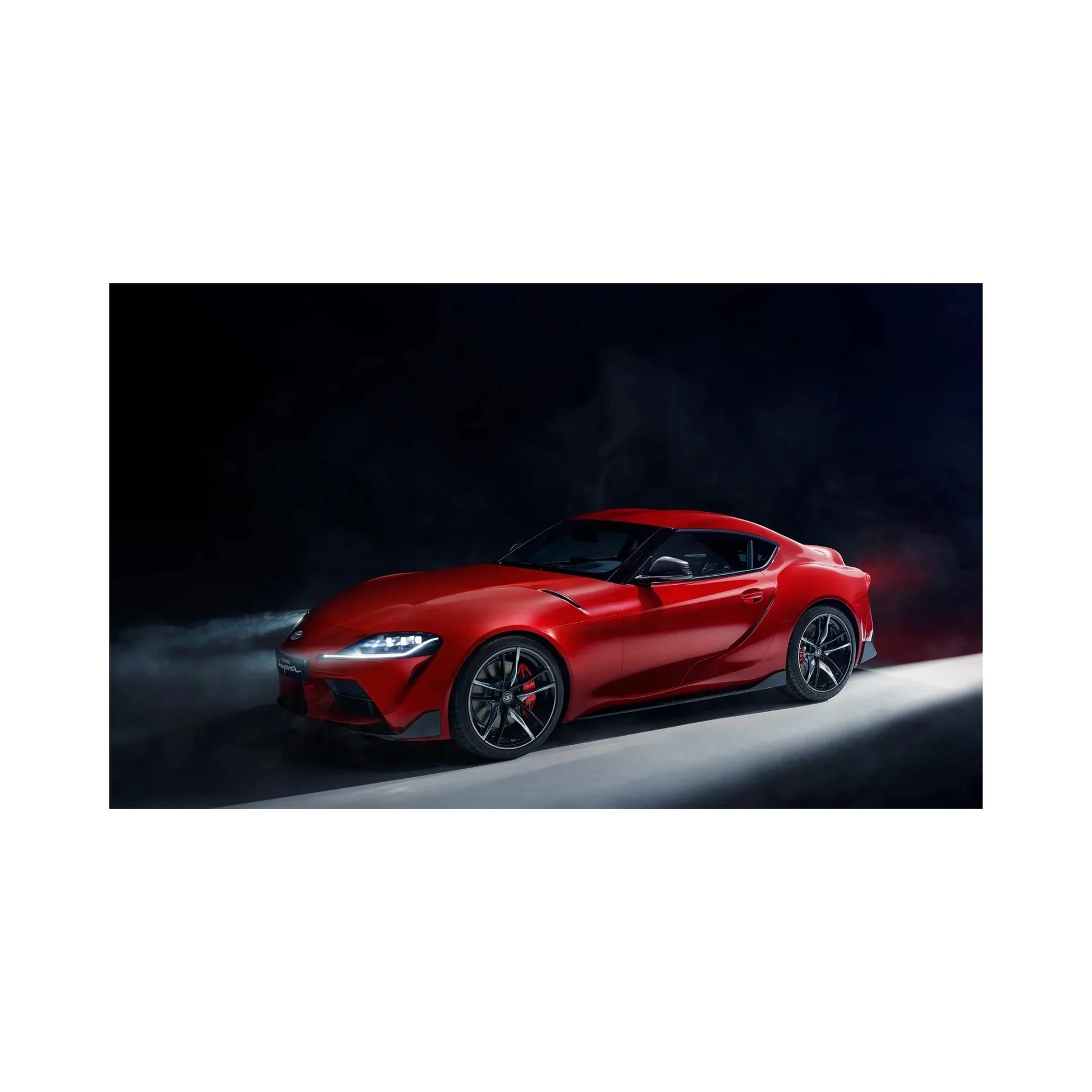Sleek red sports car in dark studio with illuminated headlights and stylish alloy wheels