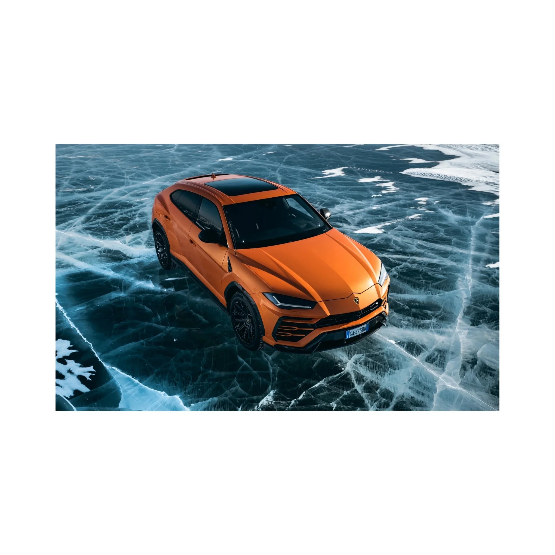 Orange Lamborghini Urus SUV parked on cracked icy frozen lake surface with snow patches