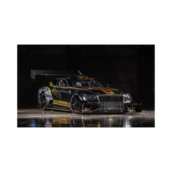 Black and gold Bentley race car with aerodynamic features in dark indoor setting